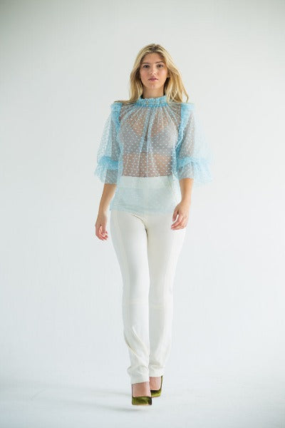 sheer polka dot blouse with cream pants